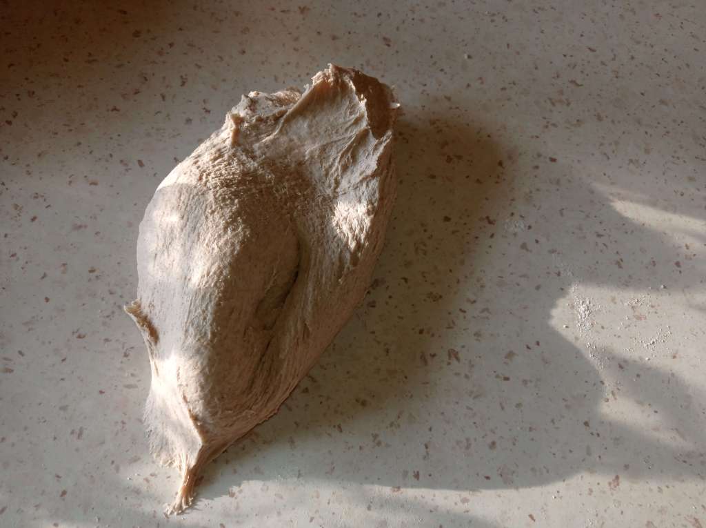 Bread dough at different kneading stages on a floured work surface