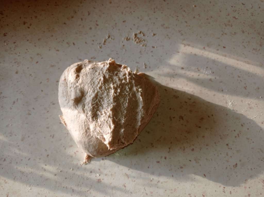 Bread dough at different kneading stages on a floured work surface