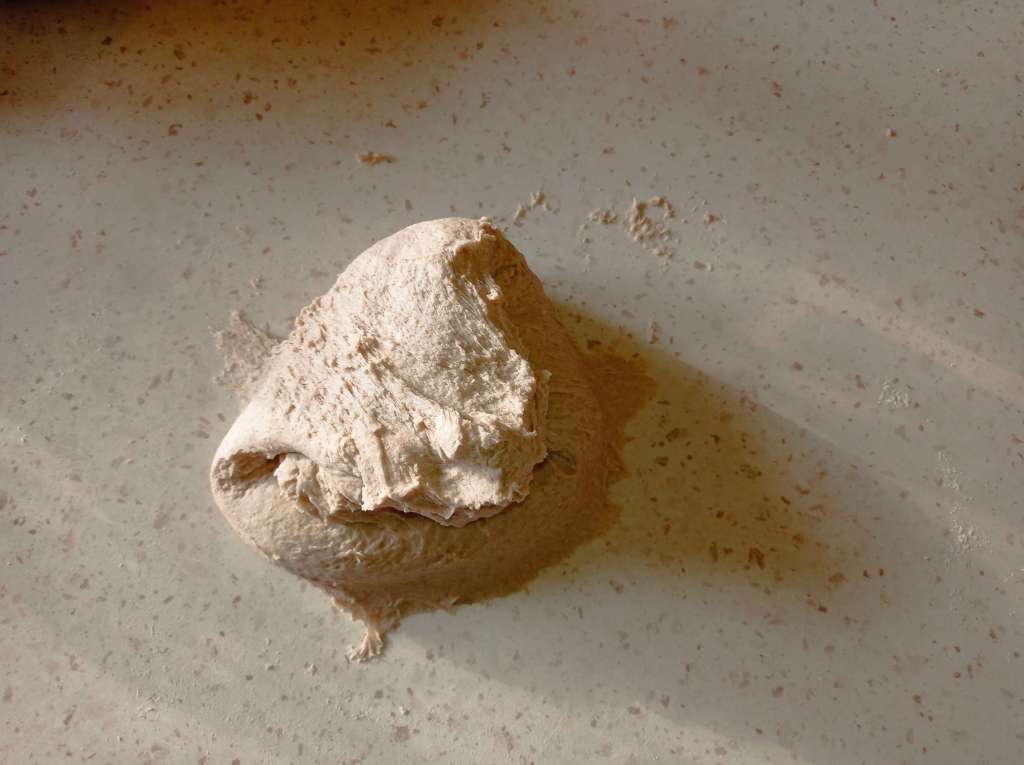 Bread dough at different kneading stages on a floured work surface