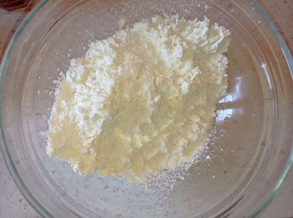 Close-up of sifted milk powder in a clear glass bowl, ready for use