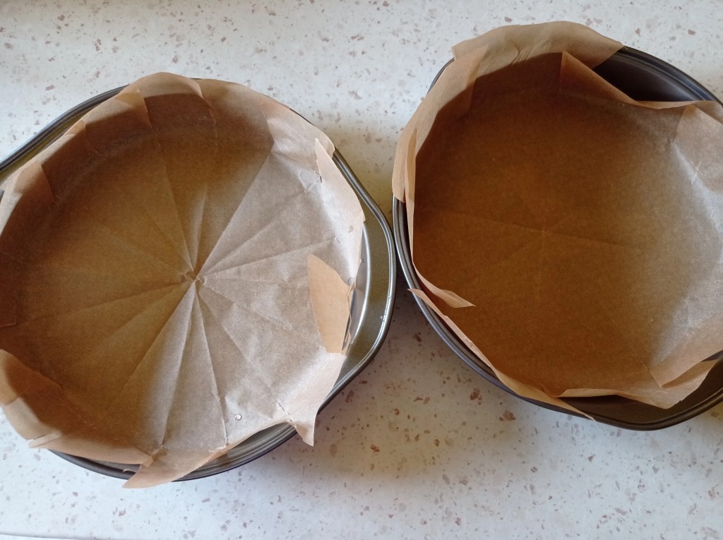 Two springform pans lined with parchment paper, ready for assembling Romanian Pasca