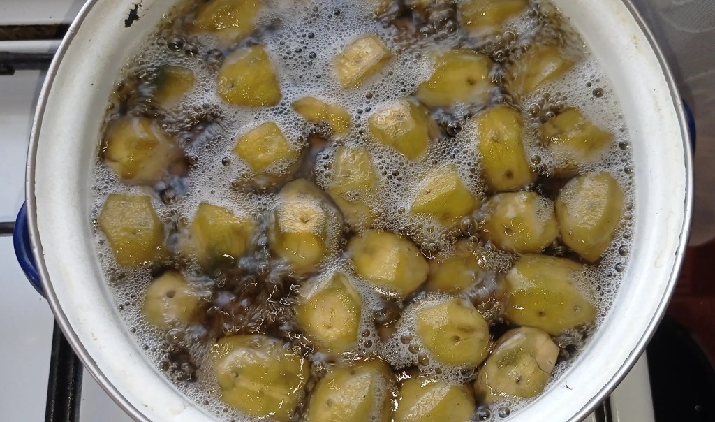 Green walnuts boiling in water during the first stage of cooking, before adding syrup.