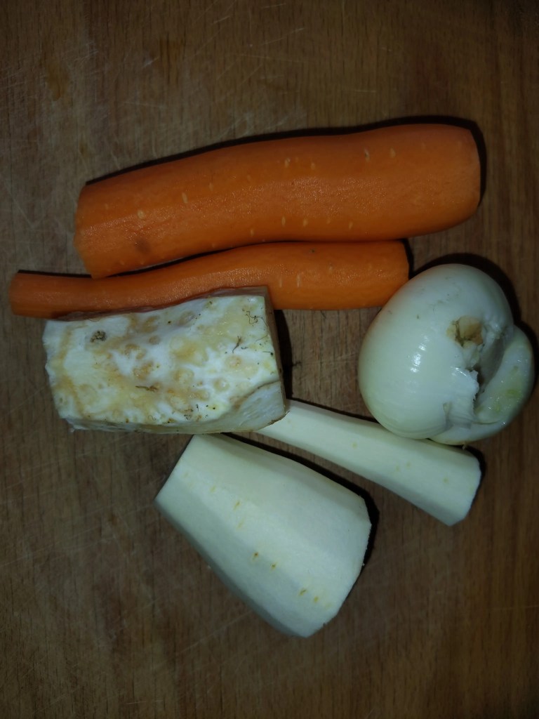 Peeled carrot, celery root, parsnip, and onion prepared for adding to the beef broth in Romanian tripe soup.