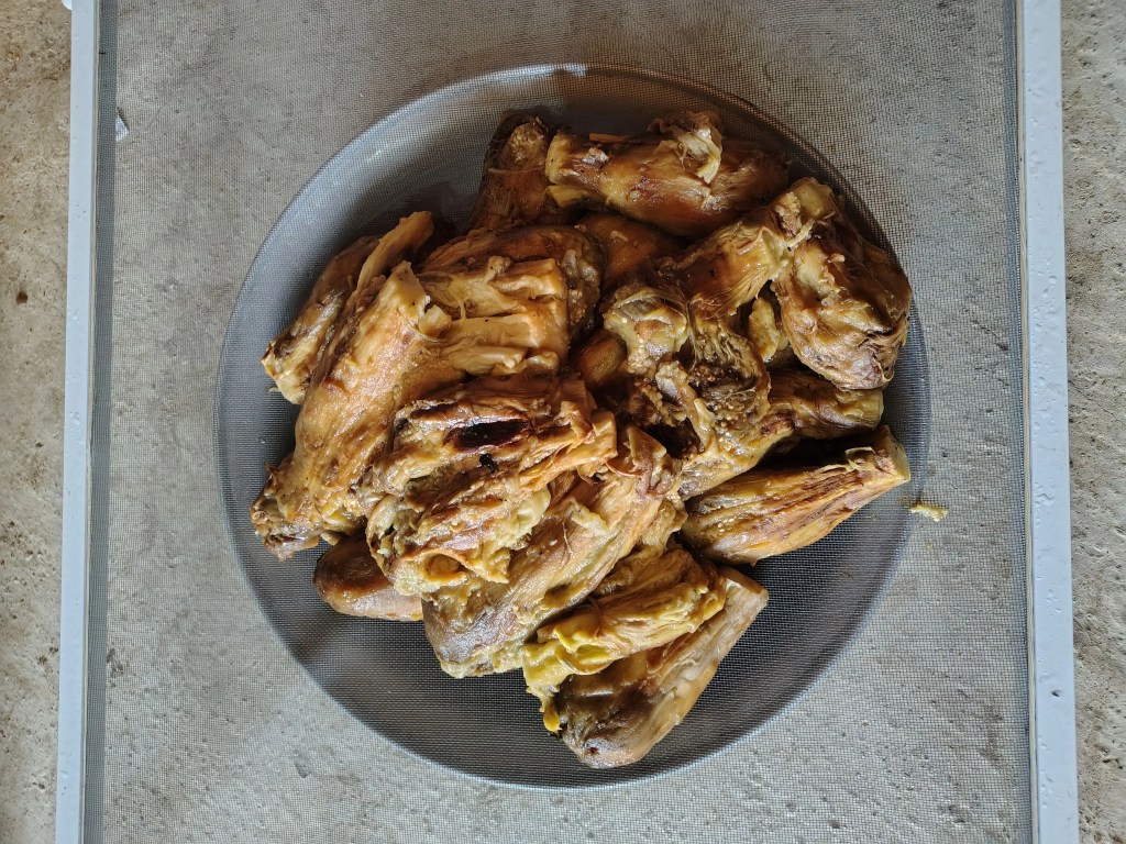 peeled roasted eggplants placed in a sieve to drain excess liquid